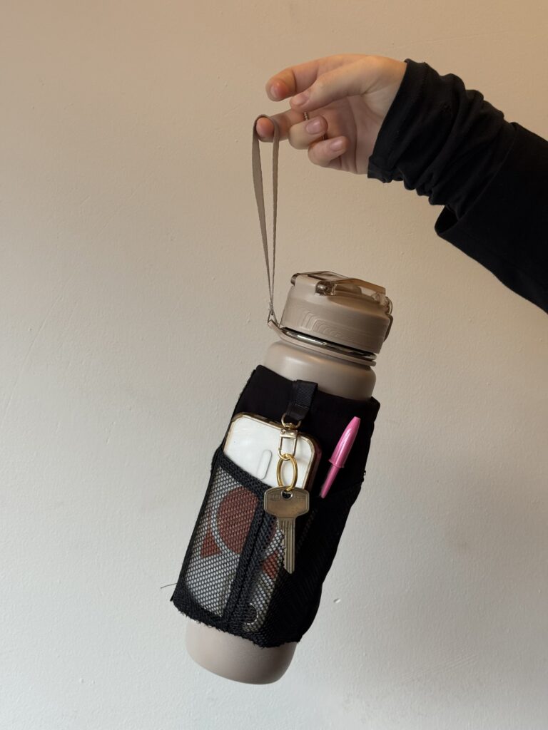 Smart water bottle ALERA with built-in storage compartment holding keys, lip balm and other small essentials.